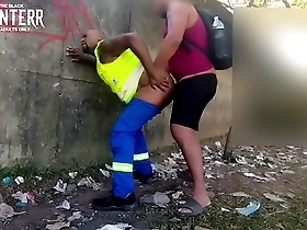 Two black men having sex in public, one of them wears work uniforms.